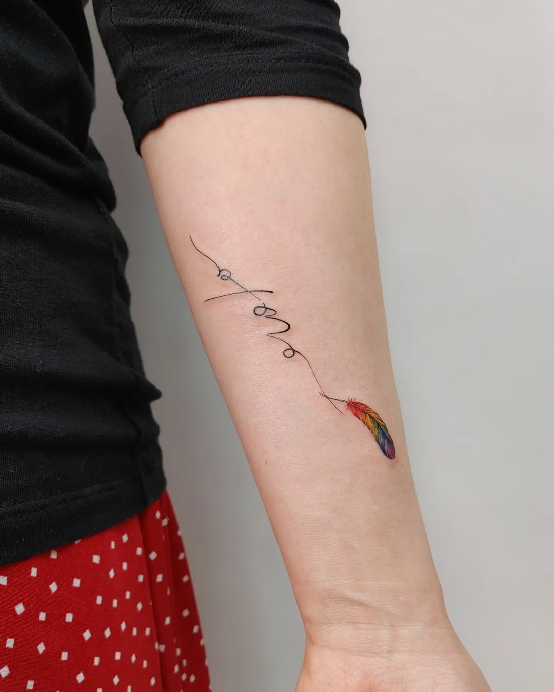 Colorful feather tattoo with inspirational script