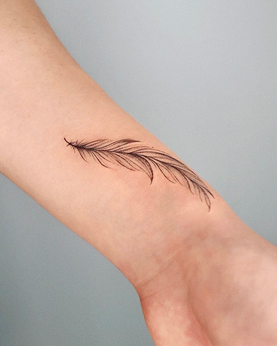 Elegant feather ink on the forearm