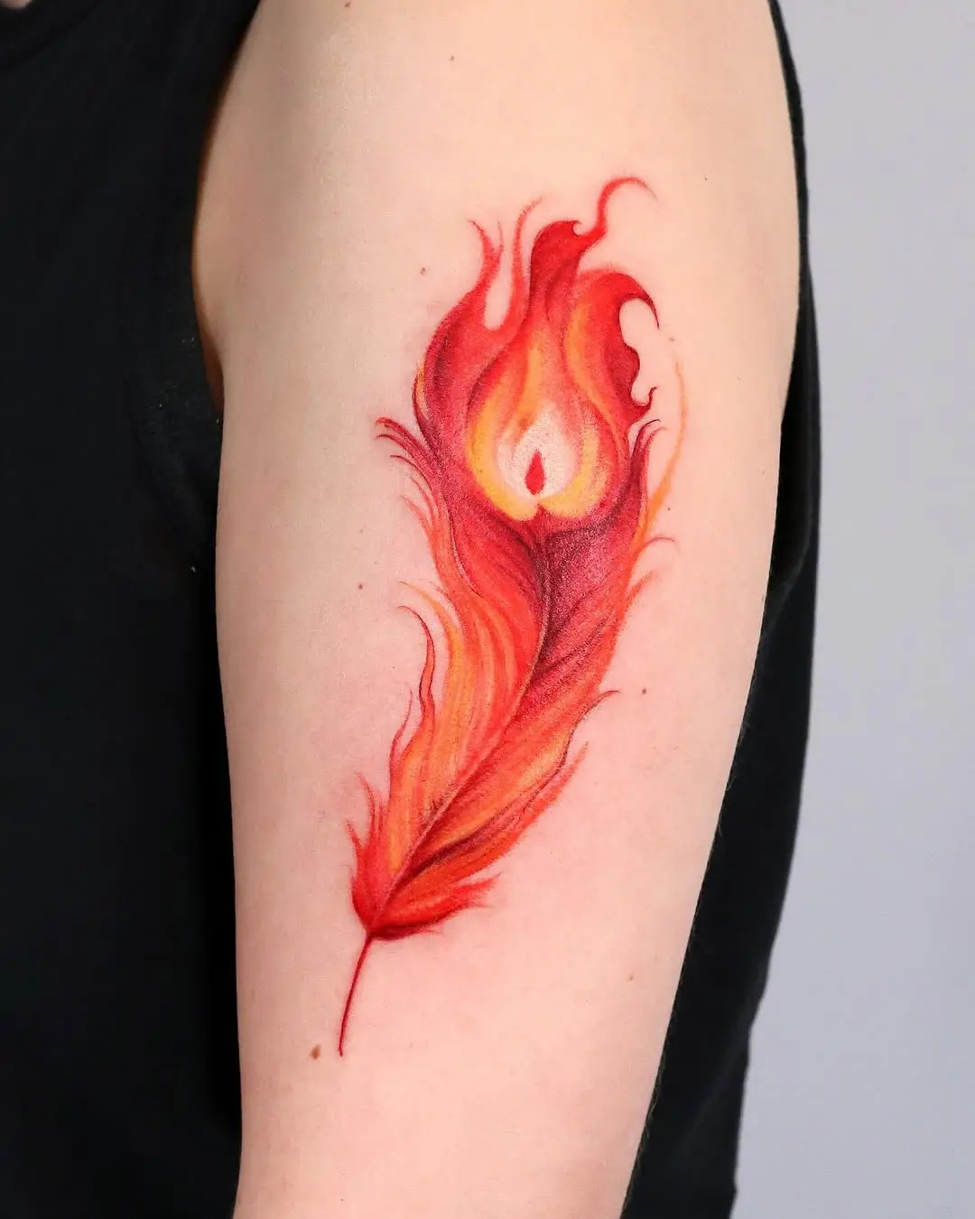 Vibrant feather tattoo with fiery aesthetics