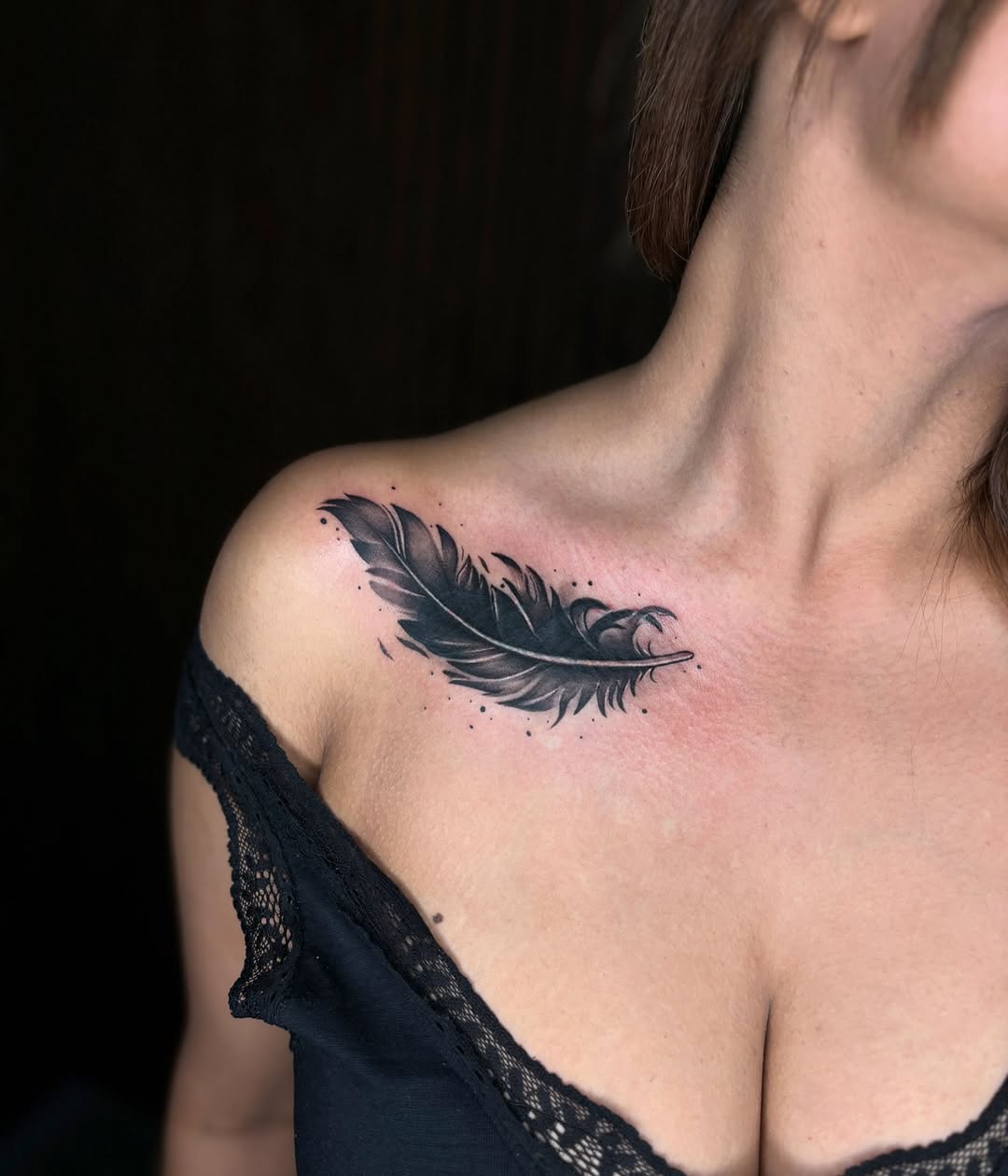 Elegant black feather tattoo on shoulder