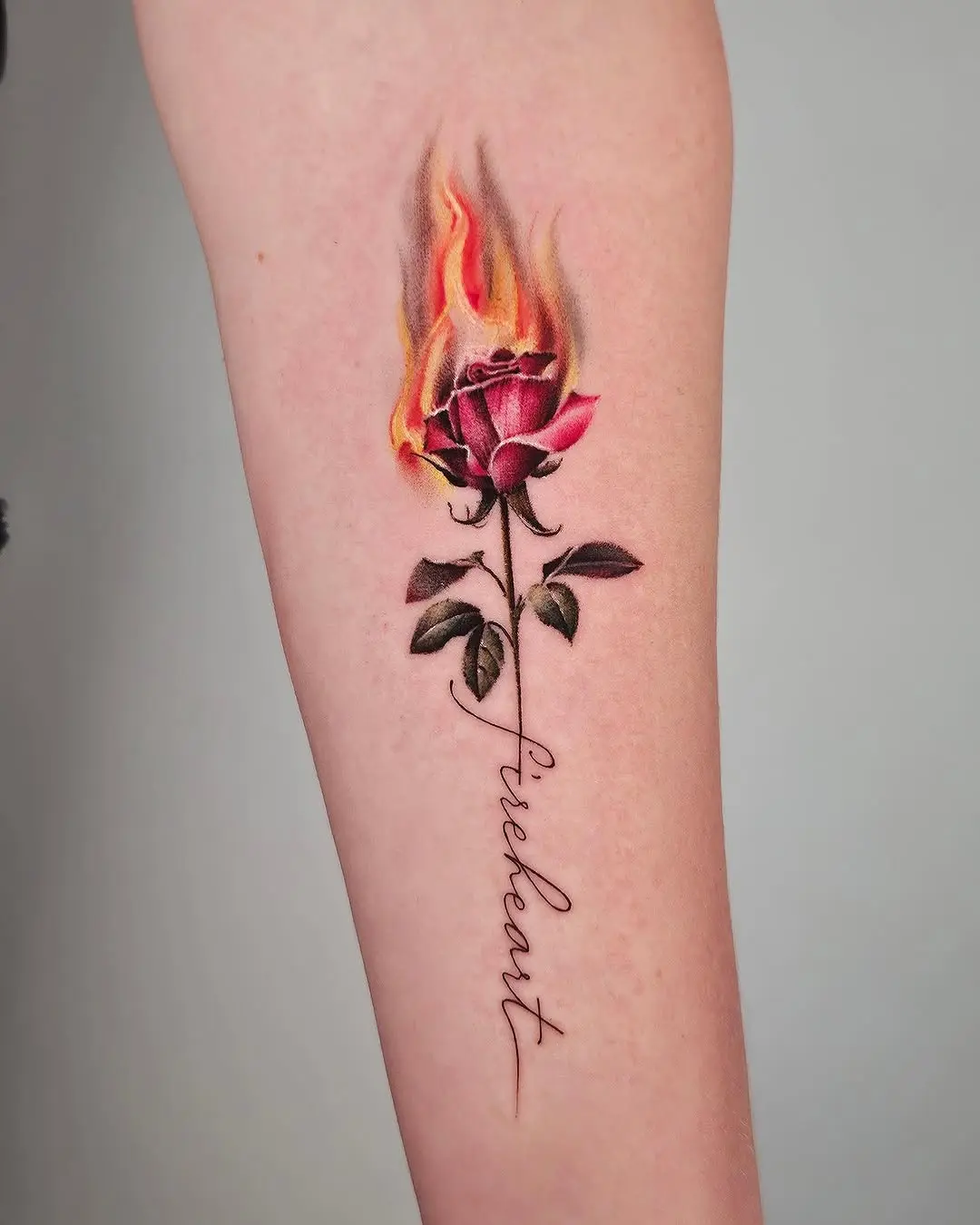 Vibrant rose tattoo engulfed in flames
