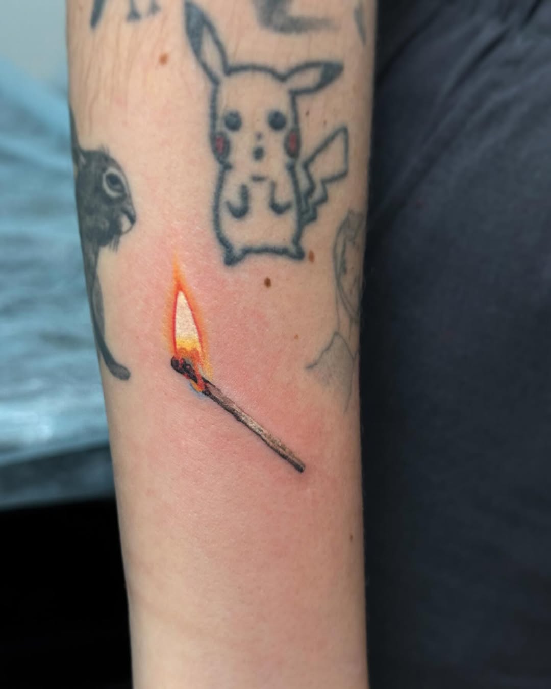 A vibrant match tattoo igniting creativity.