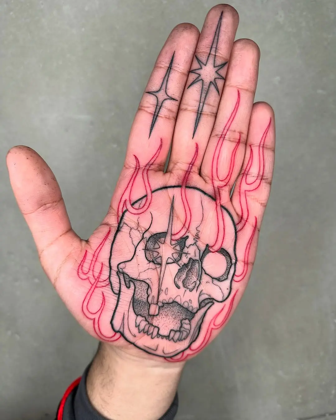 Striking fire-themed skull tattoo on hand
