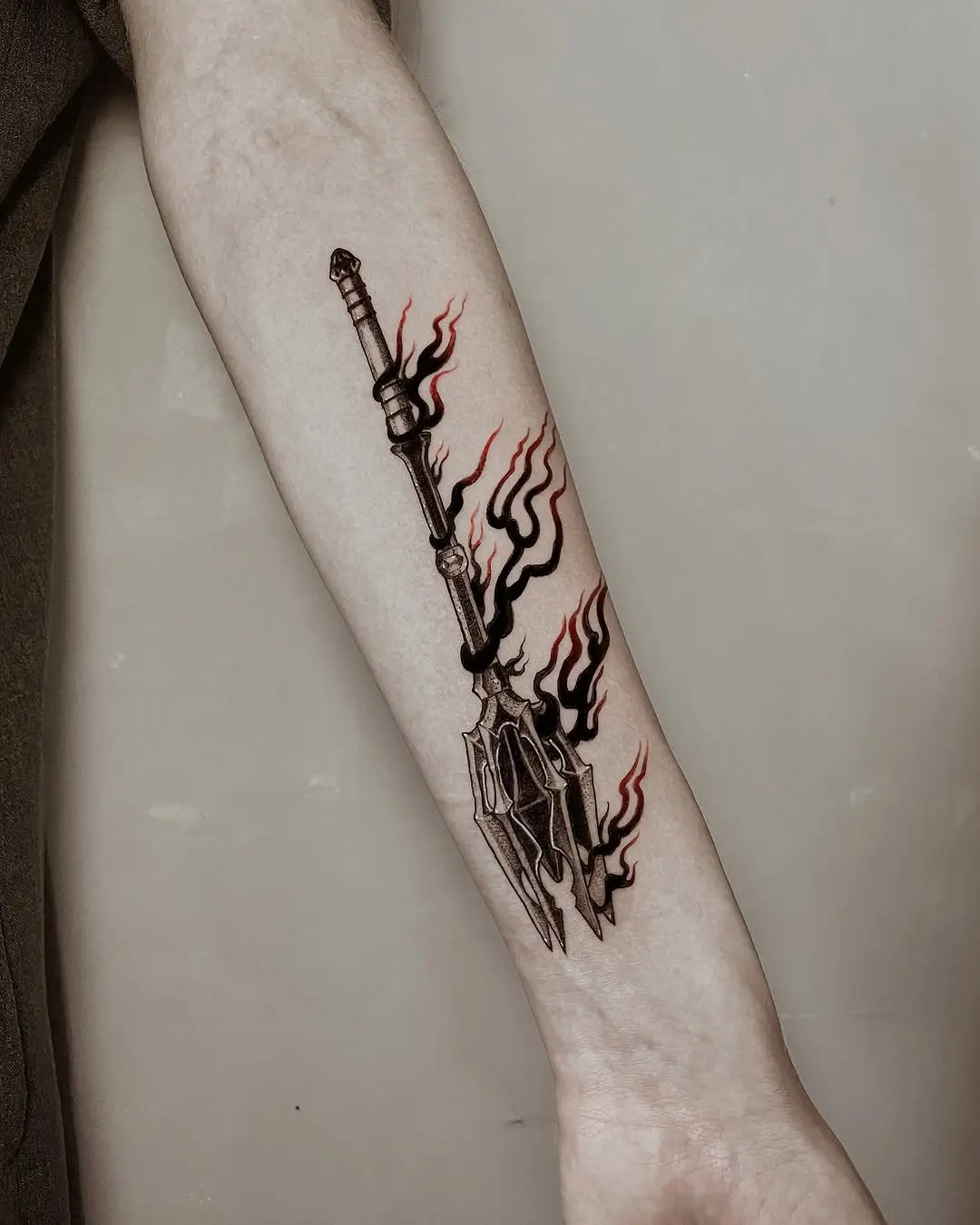 Dramatic spear tattoo with fiery accents