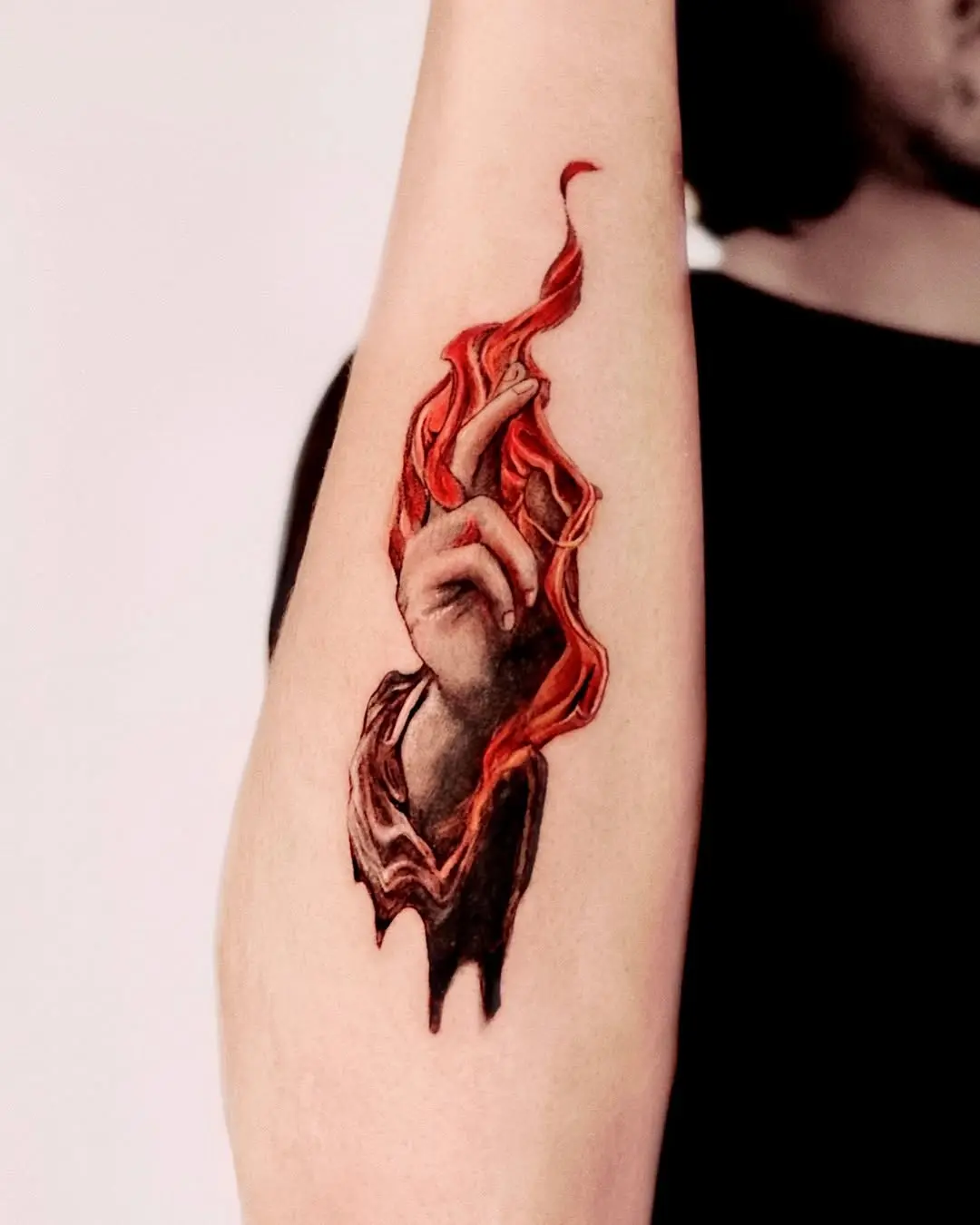 Realistic hand tattoo with fiery accents