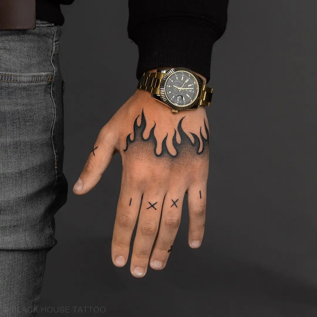 Striking hand tattoo with fiery flame designs