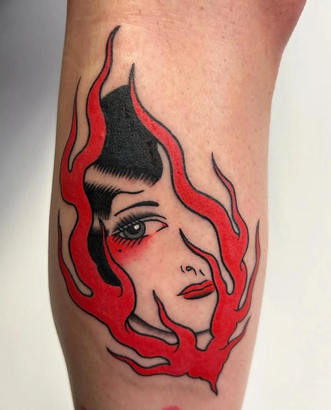Striking fire tattoo featuring a woman's face