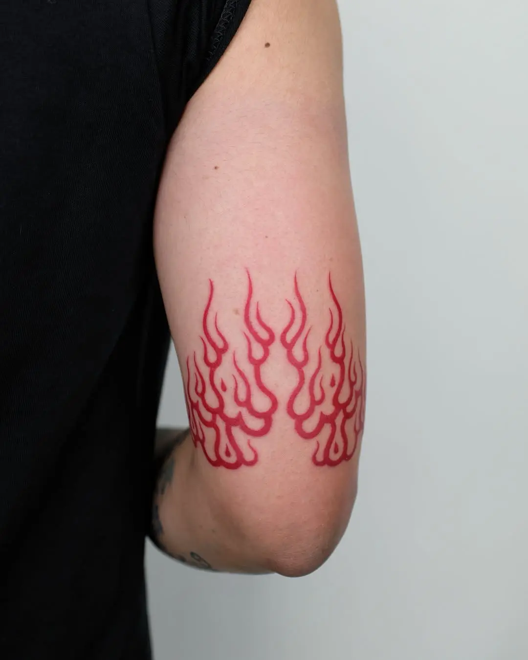 Vibrant Red Flame Tattoo Design on Elbow