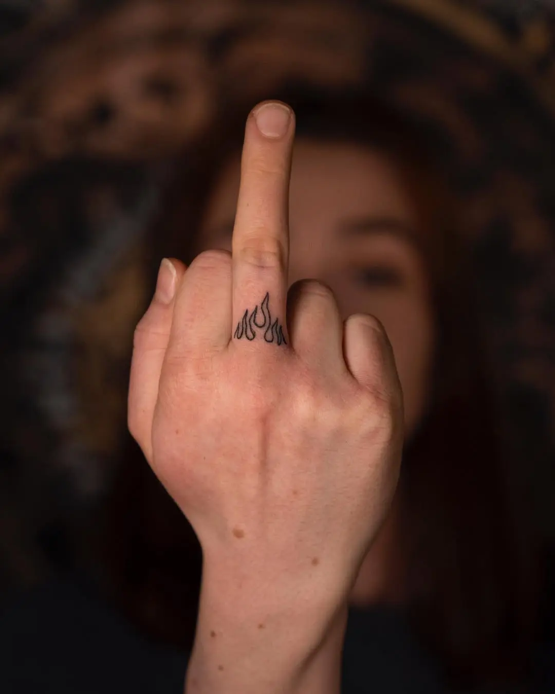 Bold fire tattoo on a raised finger
