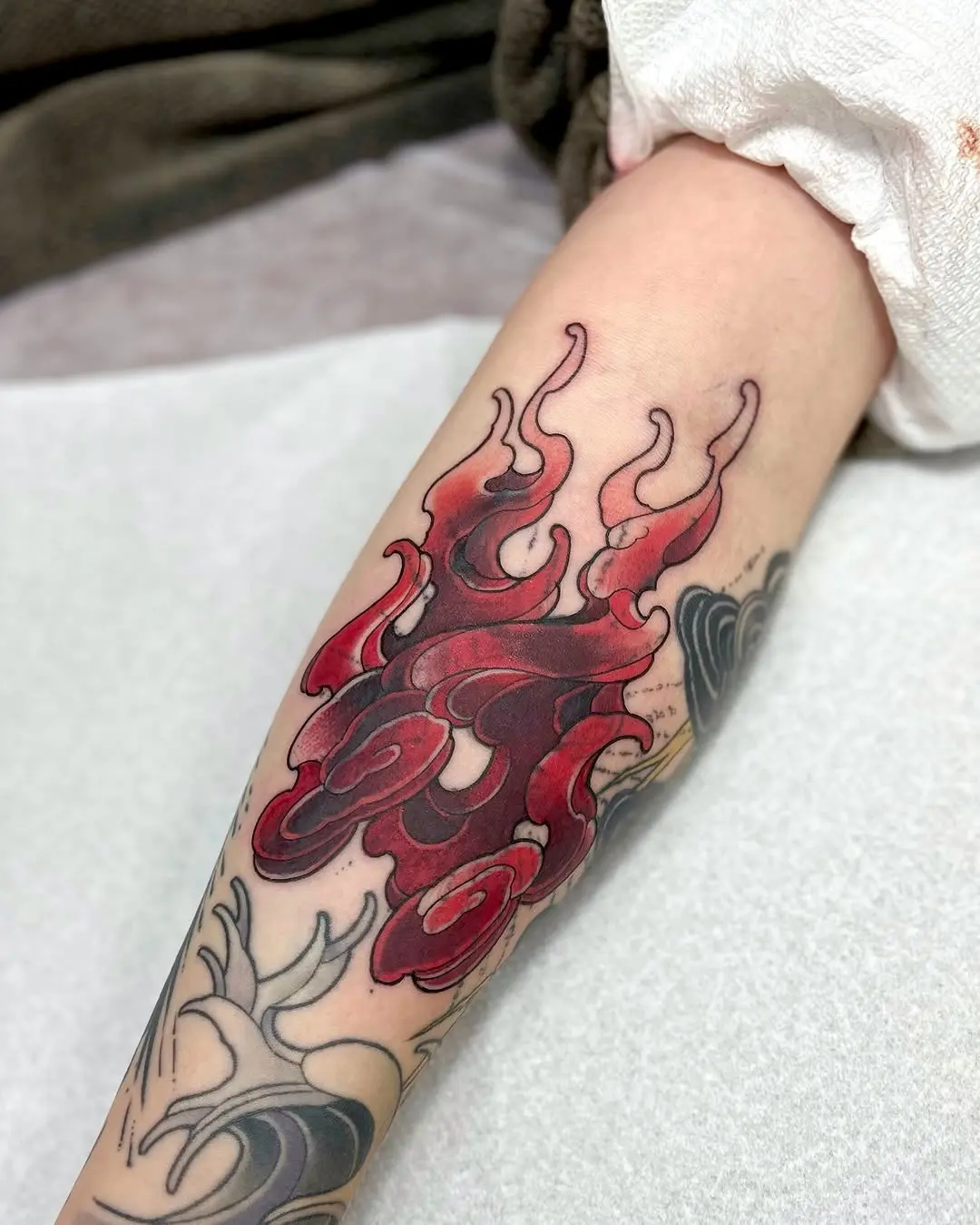 Dynamic red flame tattoo on the forearm