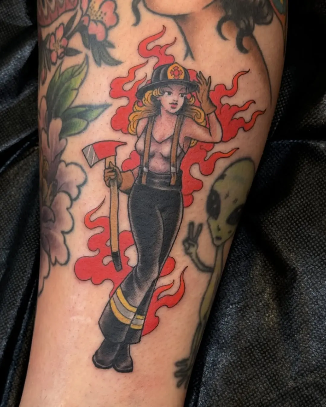 Dynamic firefighter tattoo with fiery backdrop
