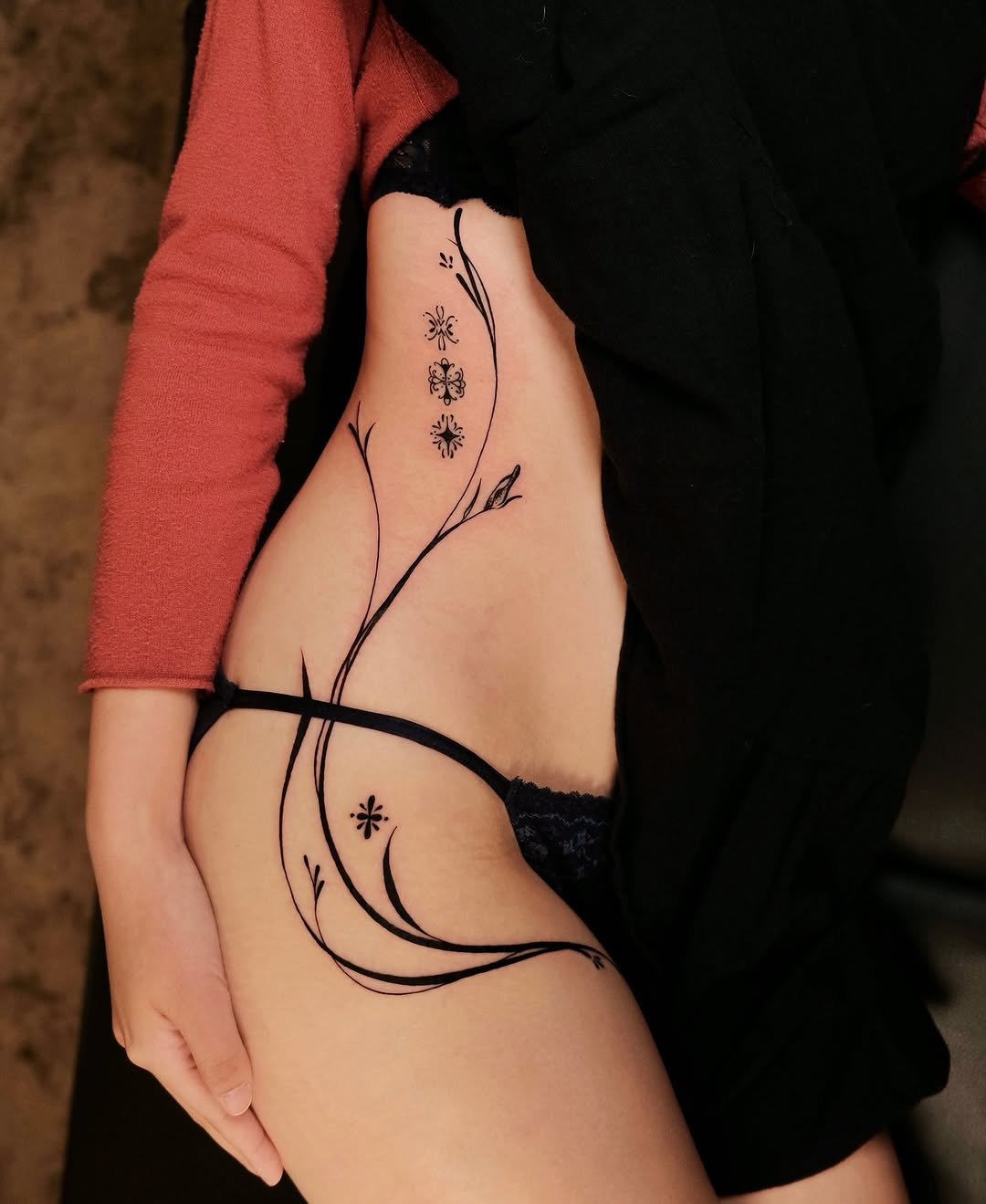 Elegant flower tattoo gracing the hip area