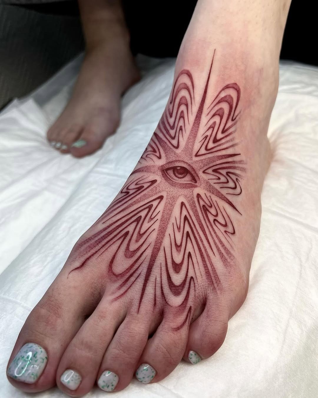 Intricate Eye Design Foot Tattoo in Red Ink