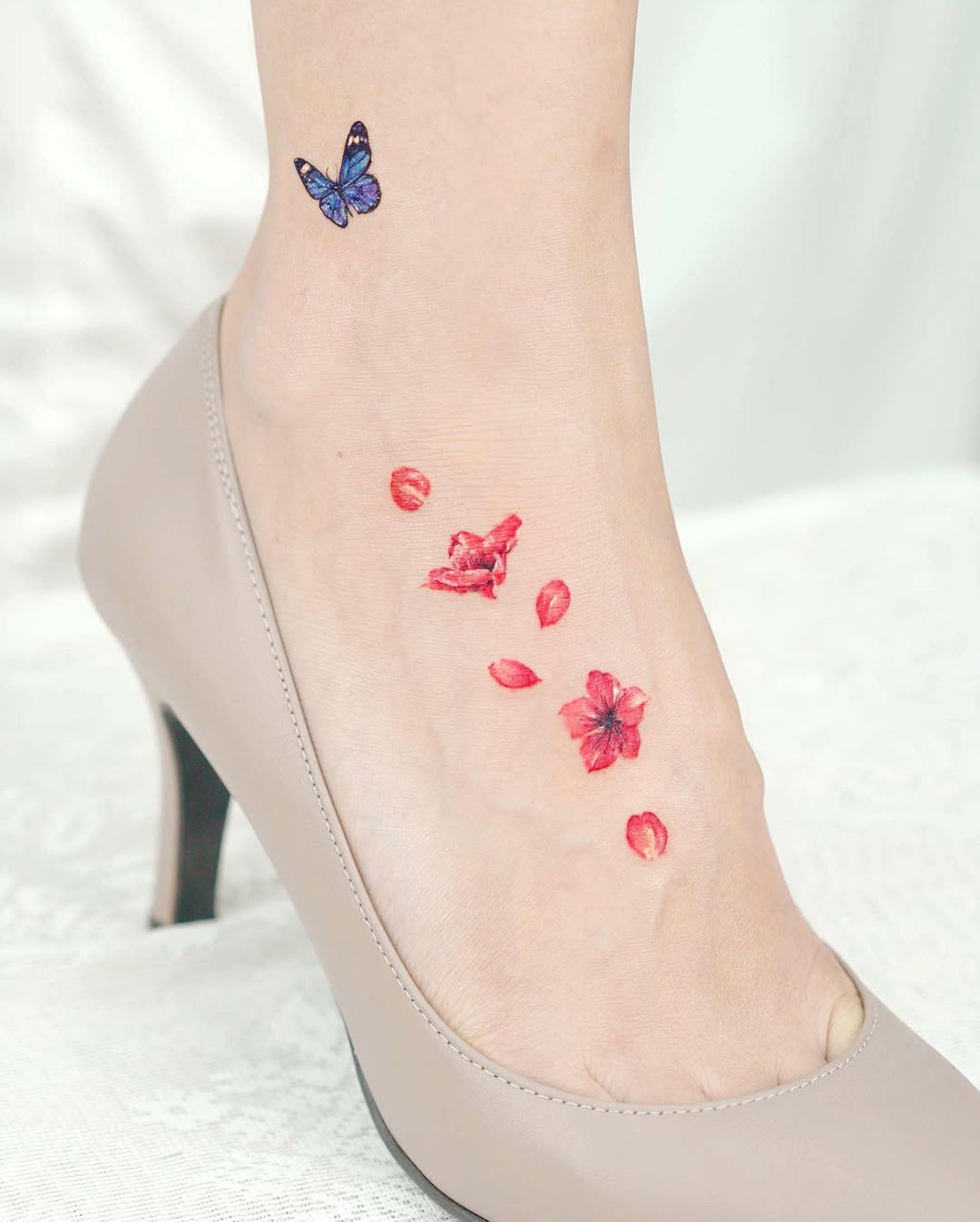 Delicate butterfly and floral foot tattoo design