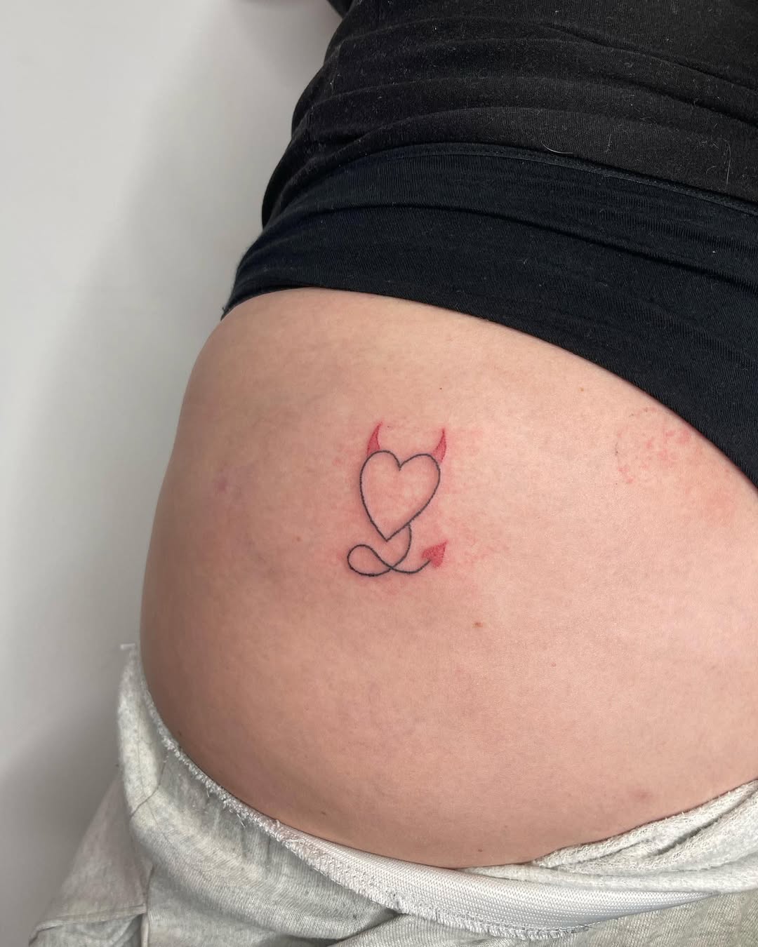 Charming heart with devilish flair tattoo