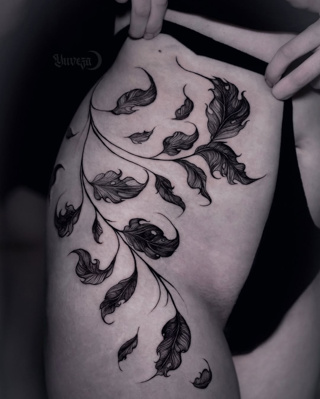 Elegant design of black leaf hip tattoo