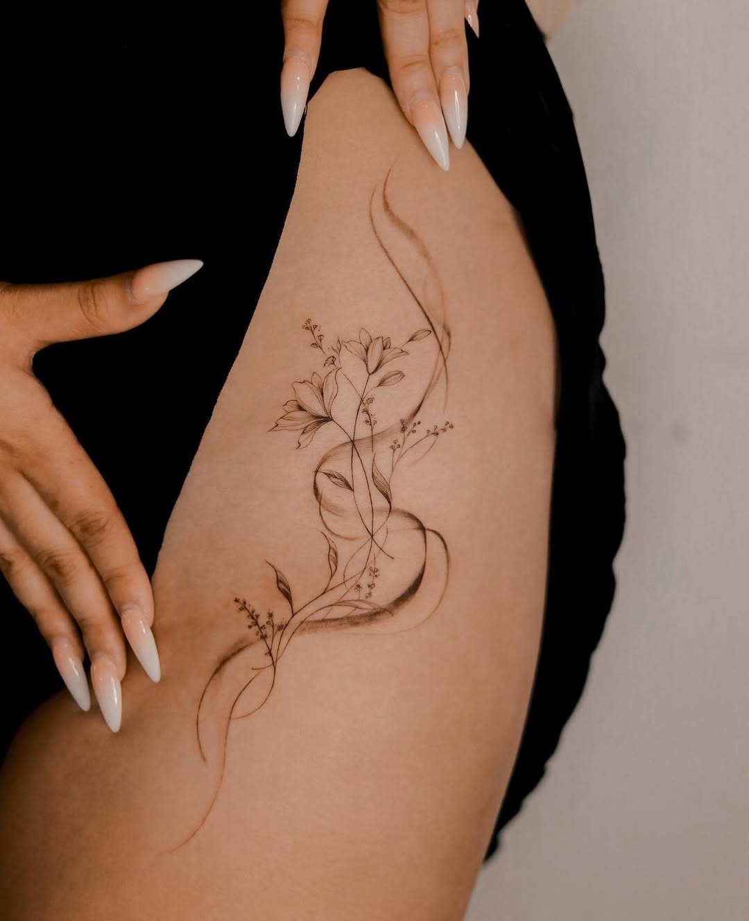 Elegant floral hip tattoo design with curls