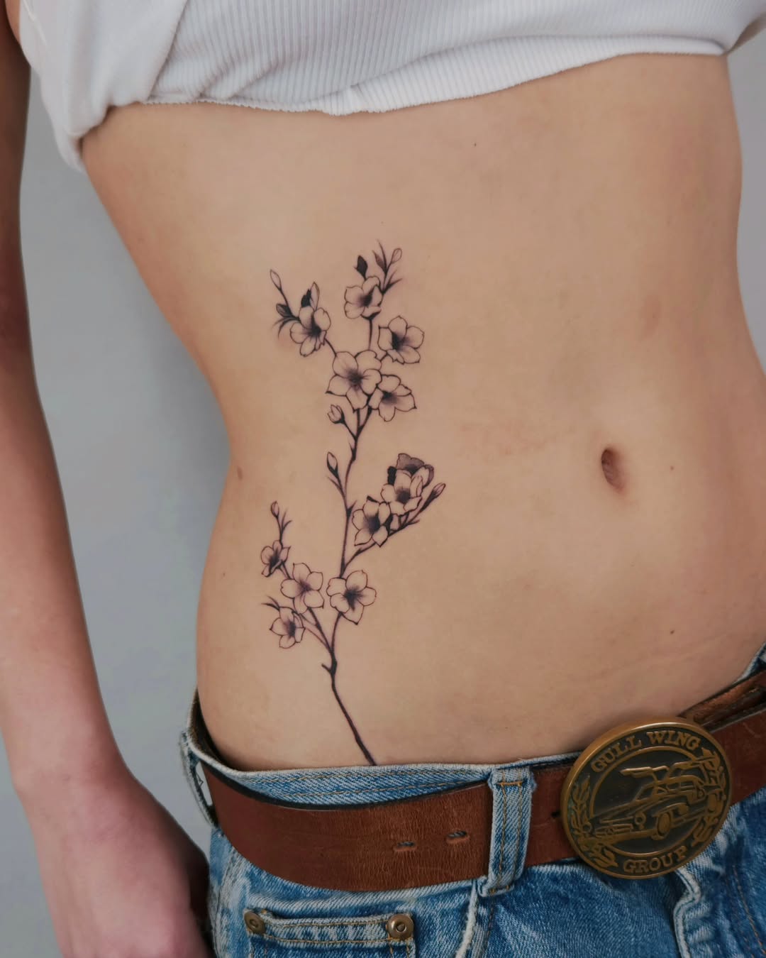 Elegant floral hip tattoo with delicate lines