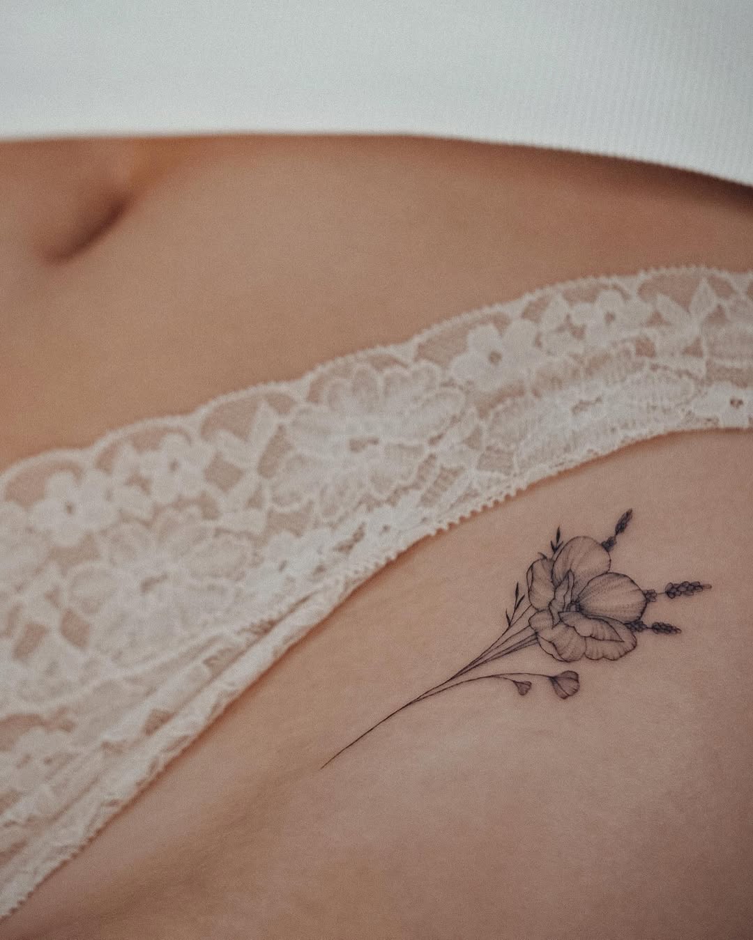 Delicate flower tattoo accentuating the hip