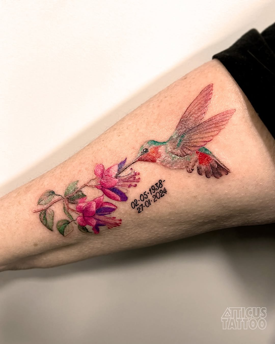 Vibrant watercolor hummingbird and floral tattoo