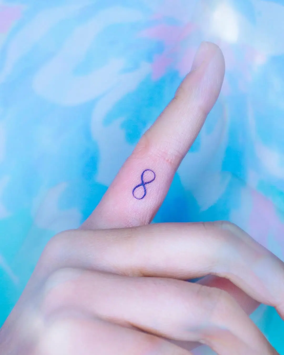 Minimalist infinity tattoo on a finger