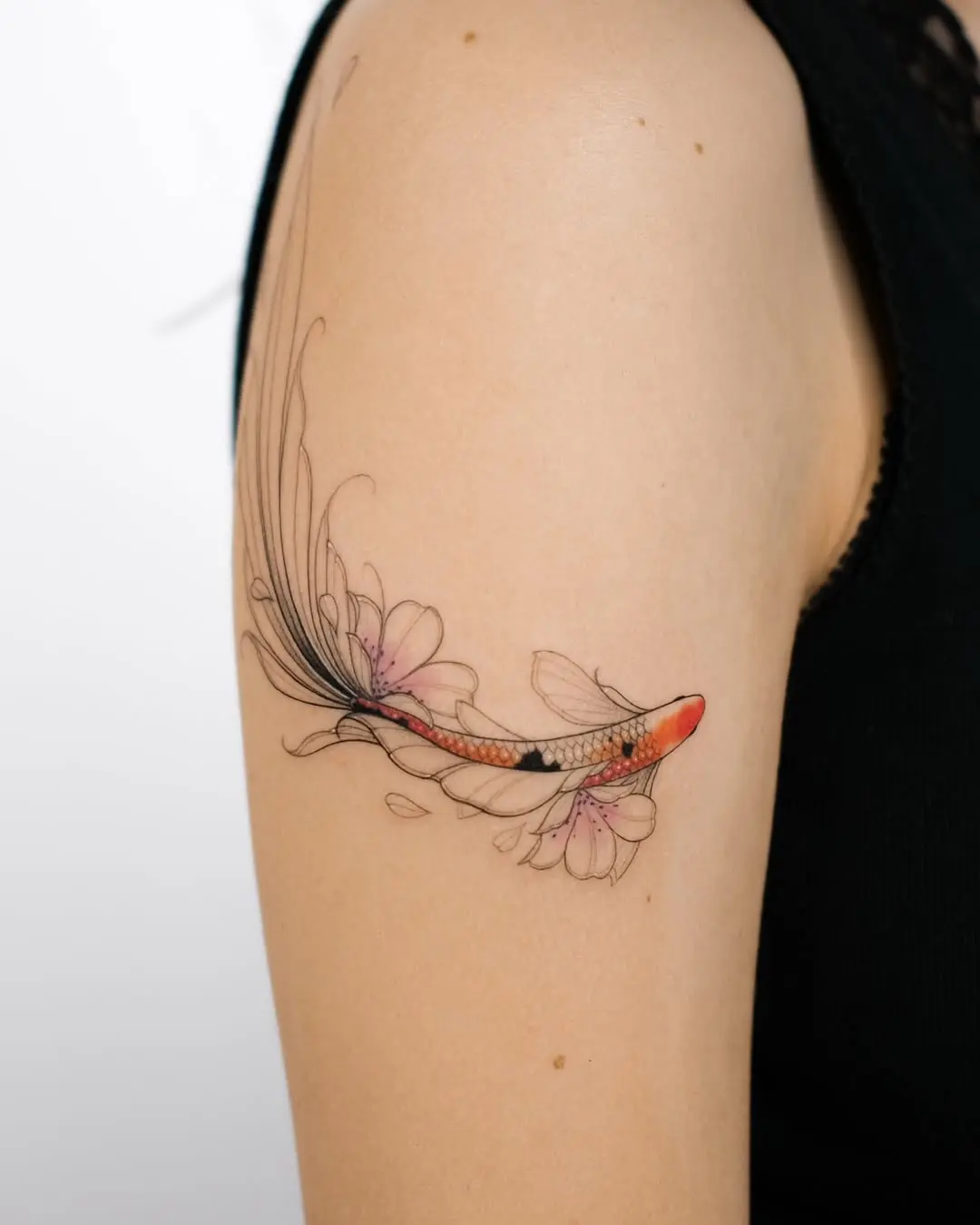 Dynamic koi fish tattoo with floral accents