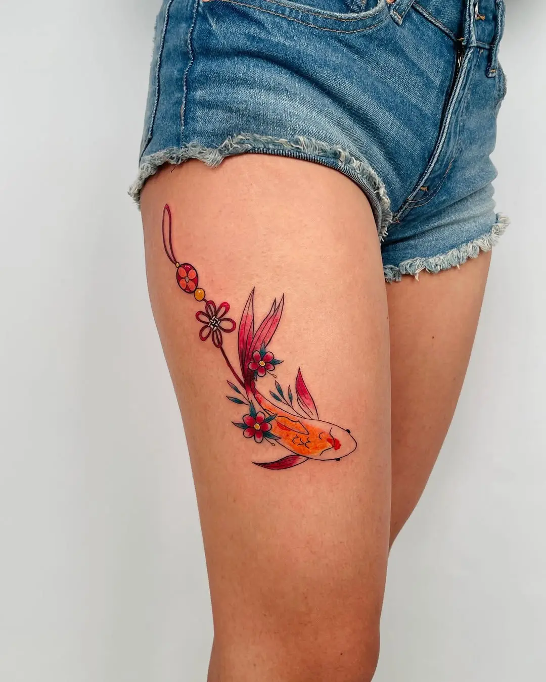 Vibrant koi fish tattoo with floral accents