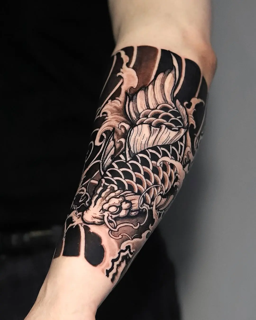 Intricate koi fish tattoo with dramatic waves