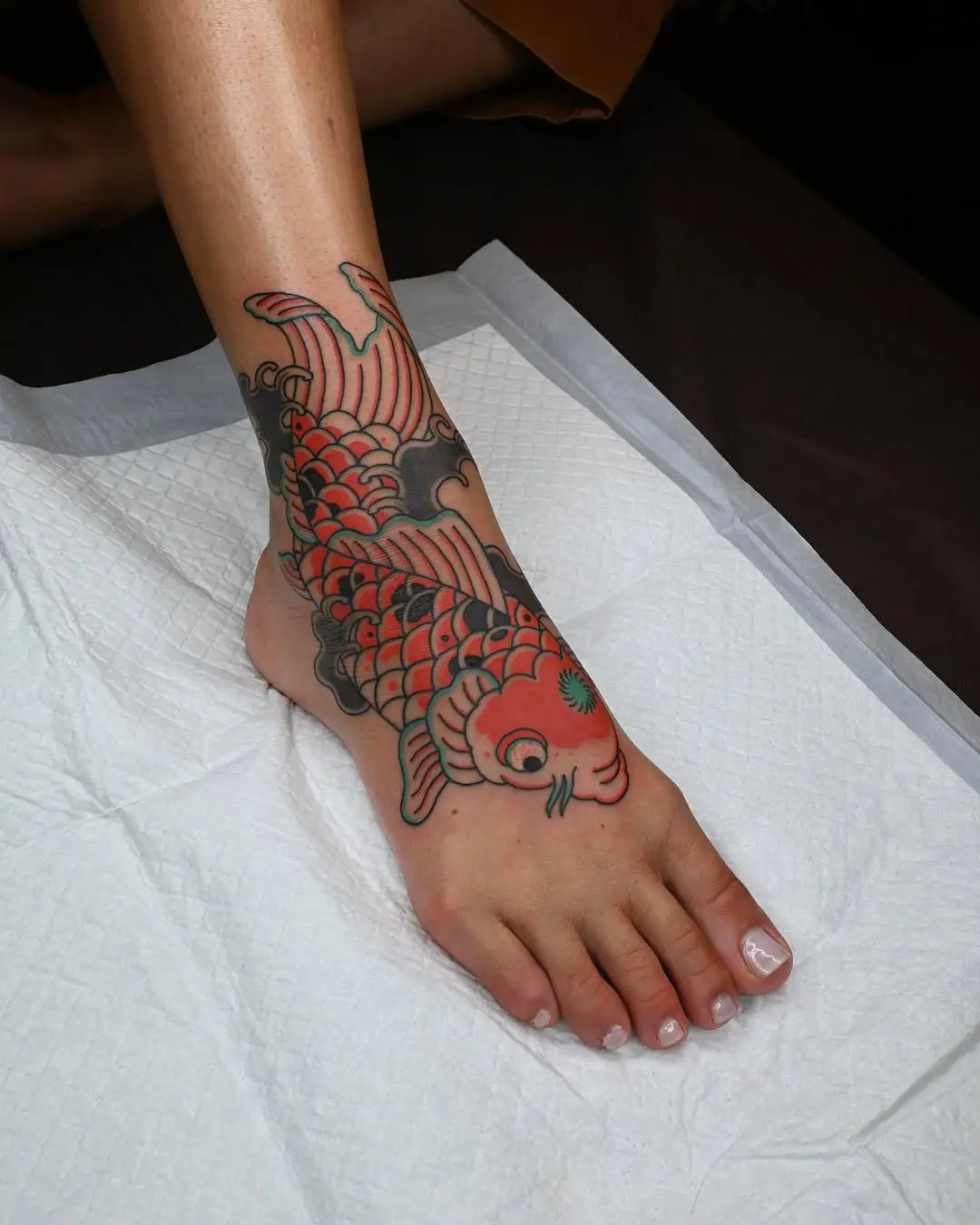 Stunning koi fish tattoo wrapping the ankle.