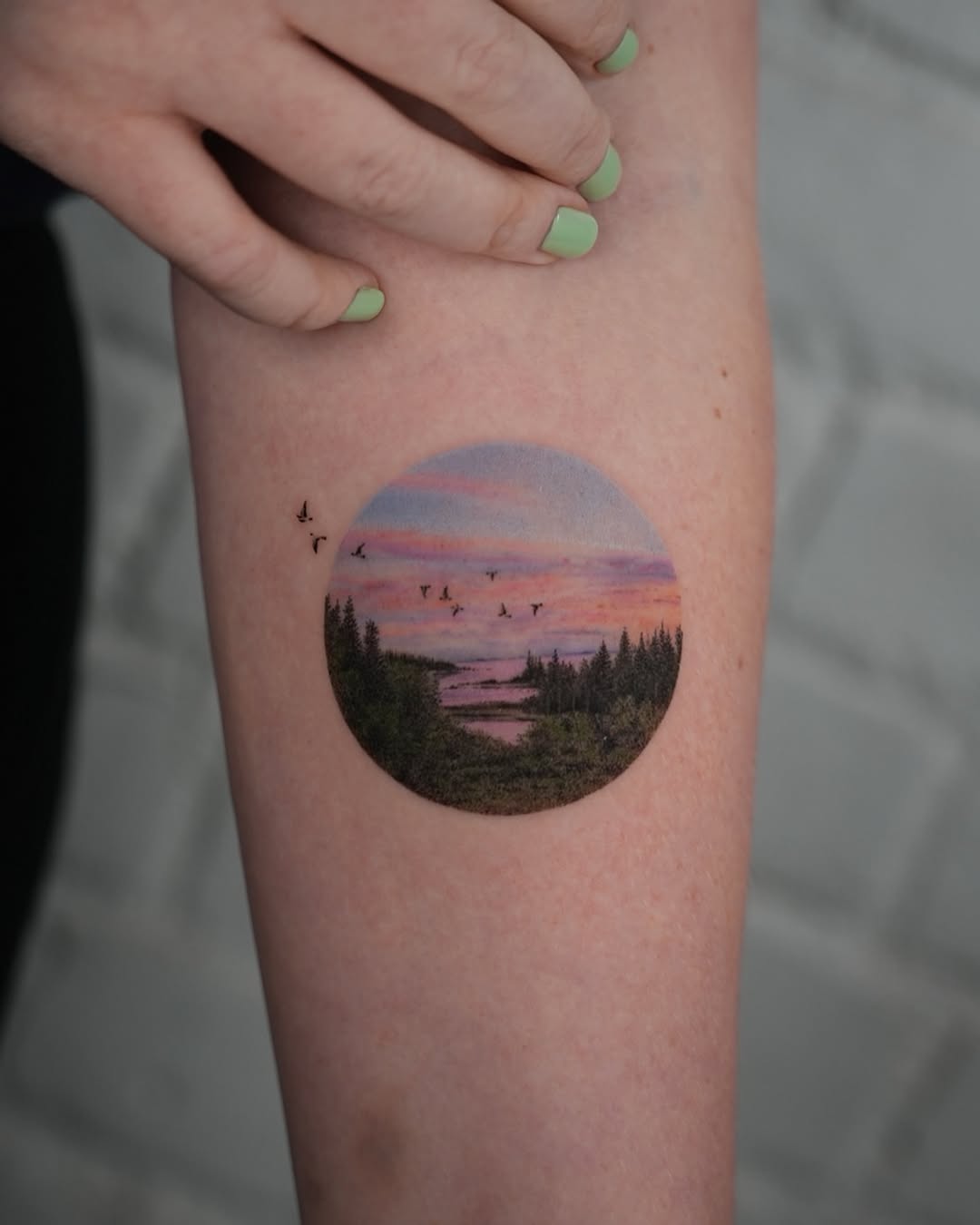 Stunning landscape tattoo featuring serene sunset scene