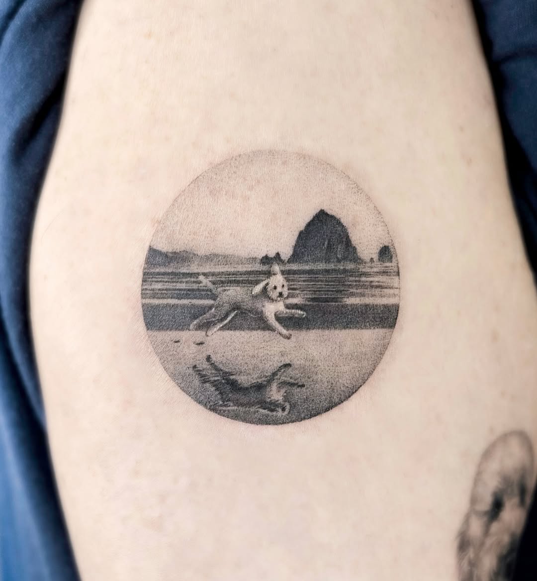 A serene landscape tattoo featuring a playful dog