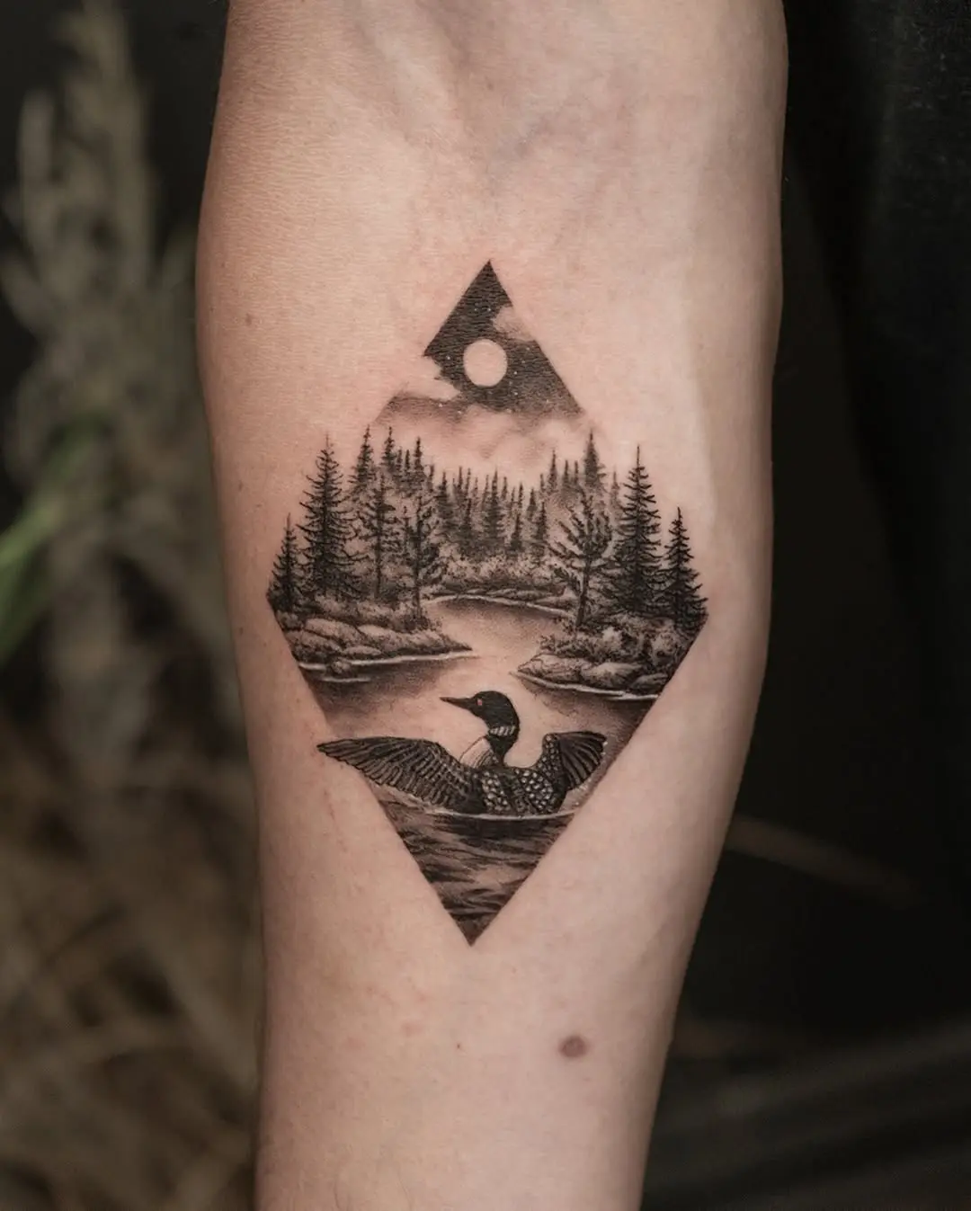 Serene landscape tattoo featuring a tranquil scene.