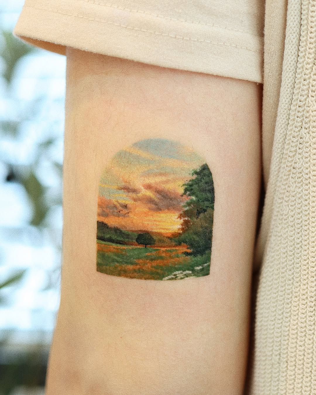 Stunning sunset landscape tattoo on the arm