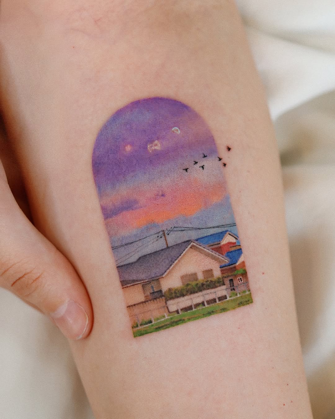 Vibrant sunset tattoo with serene landscape details