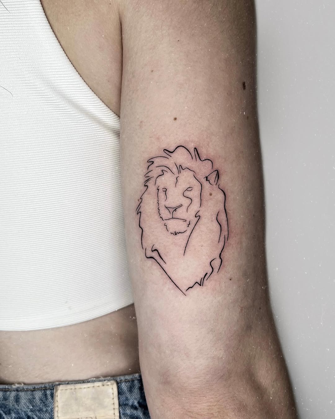 Minimalist lion tattoo design on the arm