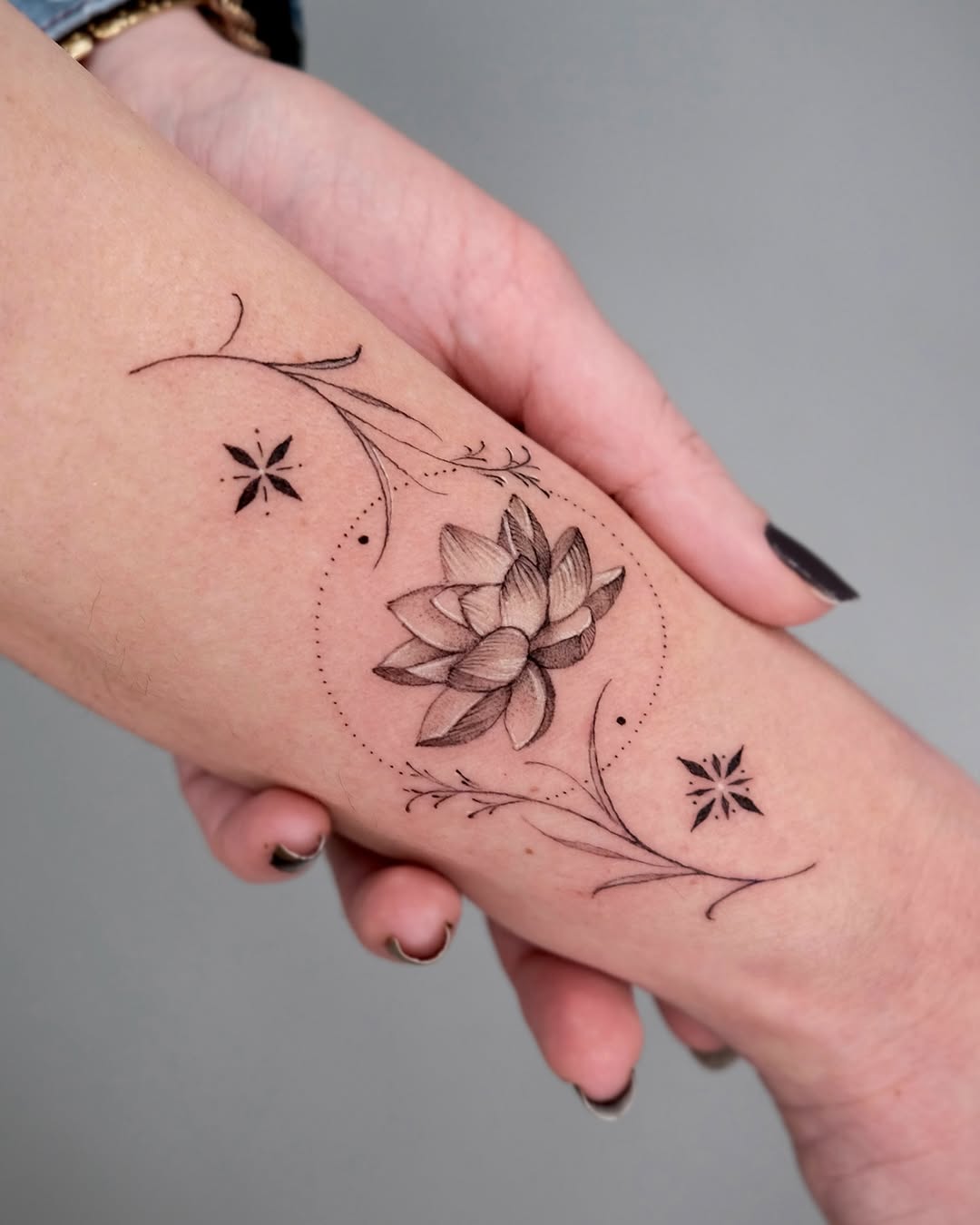 Delicate lotus tattoo with elegant floral accents