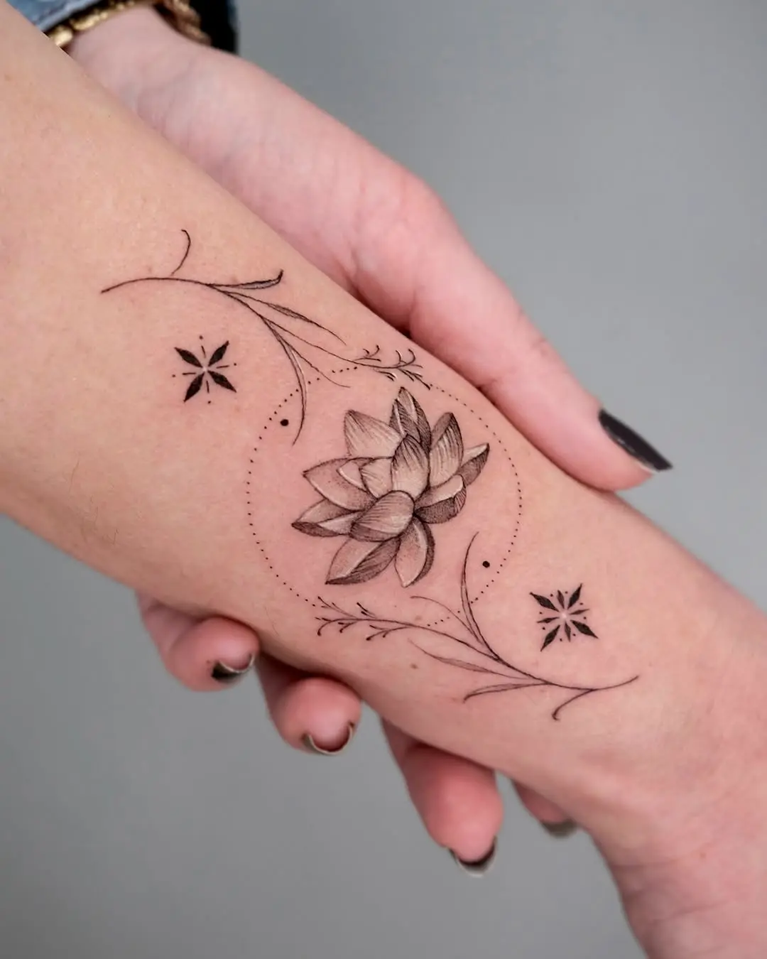 Delicate lotus tattoo with elegant floral accents