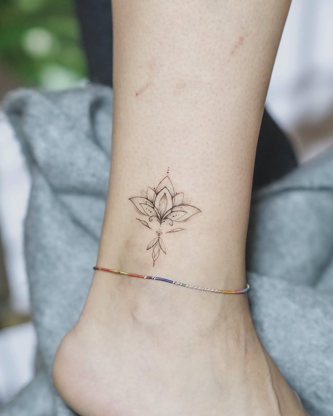 Minimalist lotus tattoo on ankle with elegance