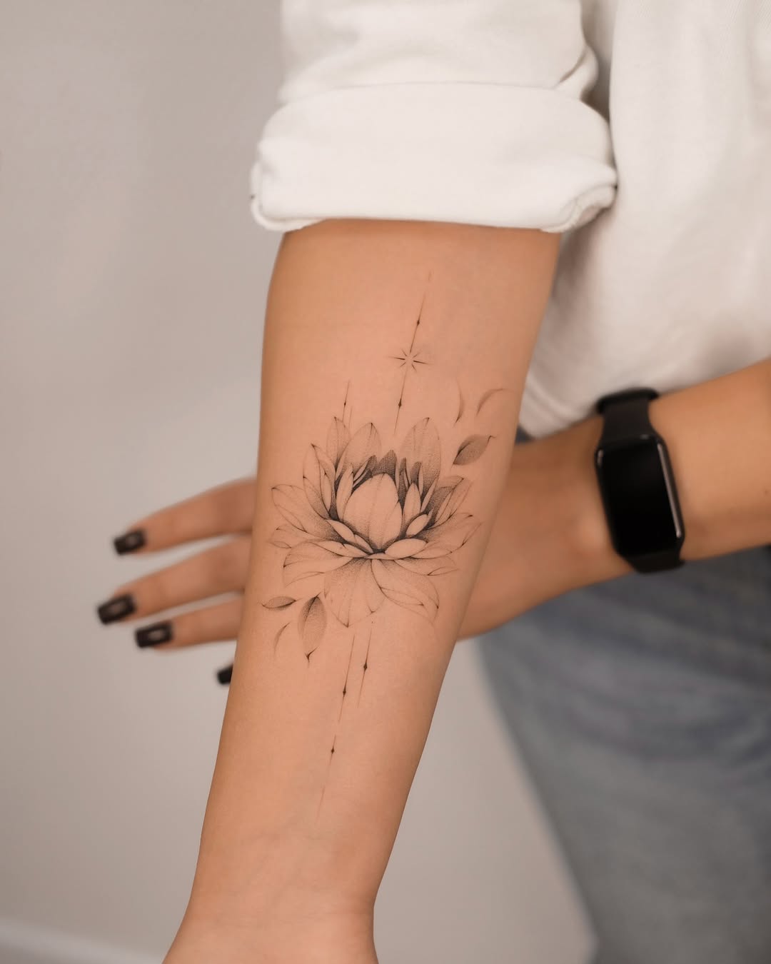 Elegant minimalist lotus tattoo on the forearm