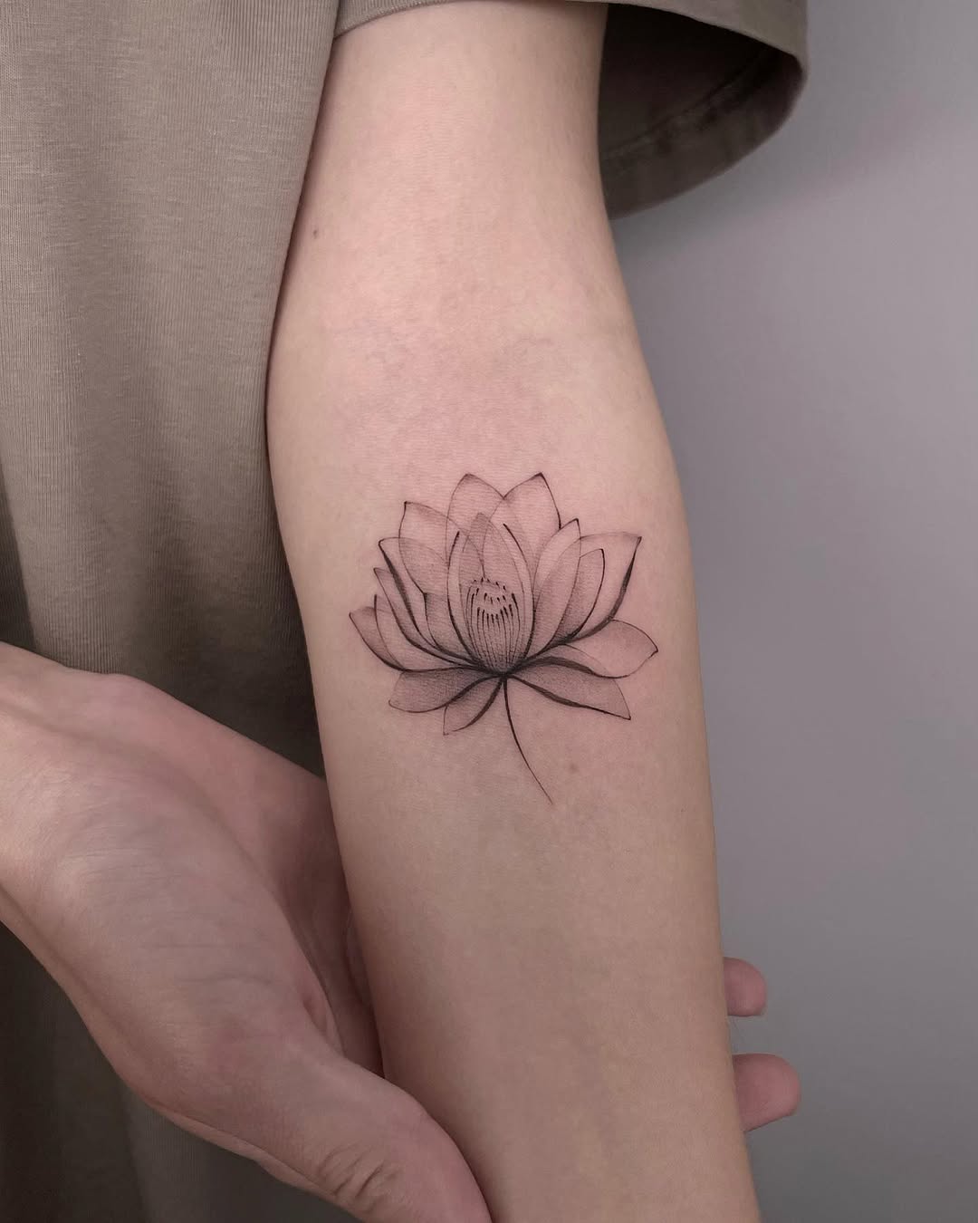 Elegant minimalist lotus tattoo design on arm