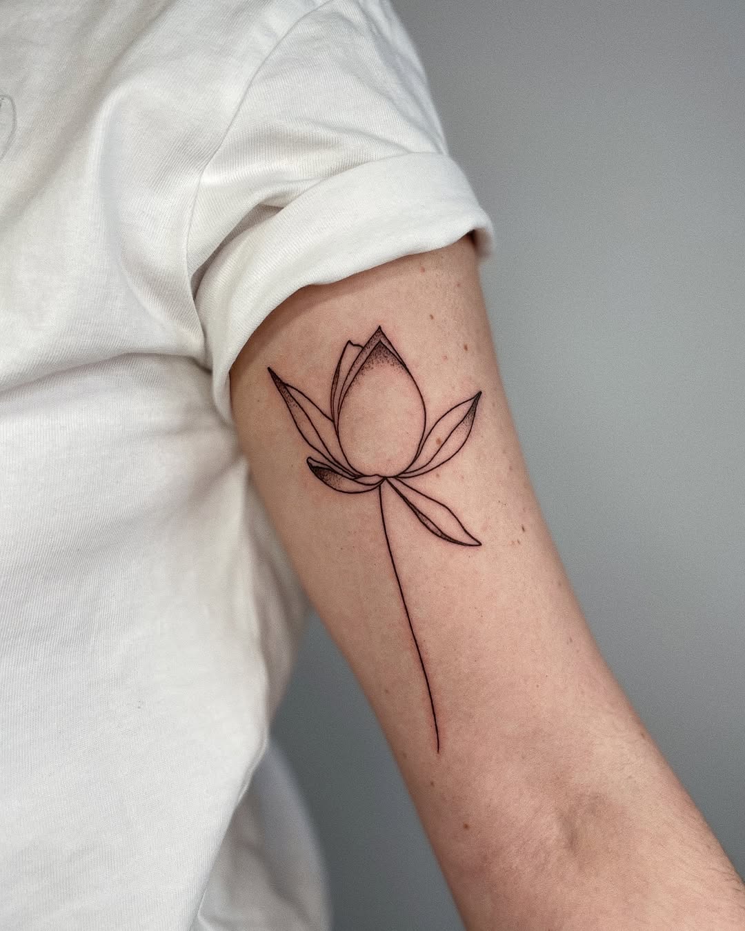 Elegant minimalist lotus tattoo on forearm