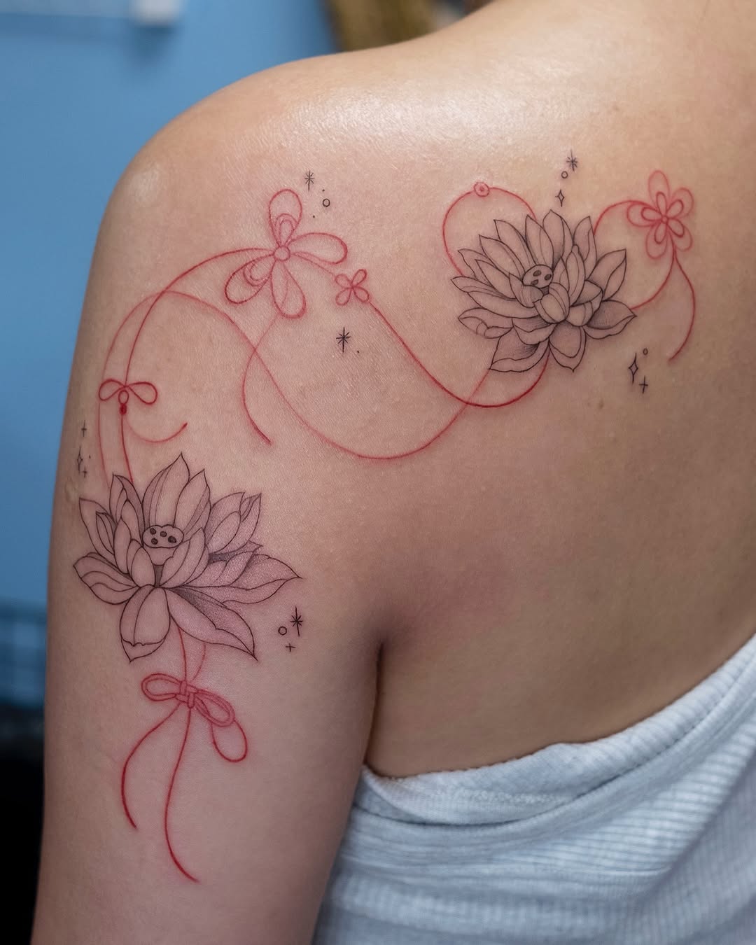 Elegant lotus tattoo with whimsical ribbon details