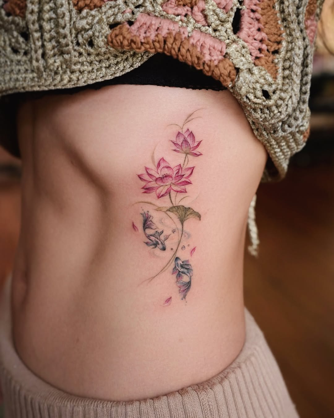 Delicate lotus tattoo with a floral touch