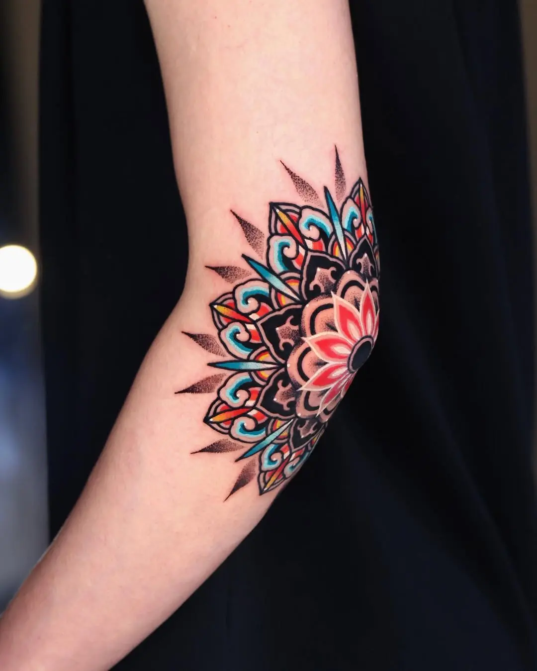Vibrant mandala elbow tattoo with intricate details