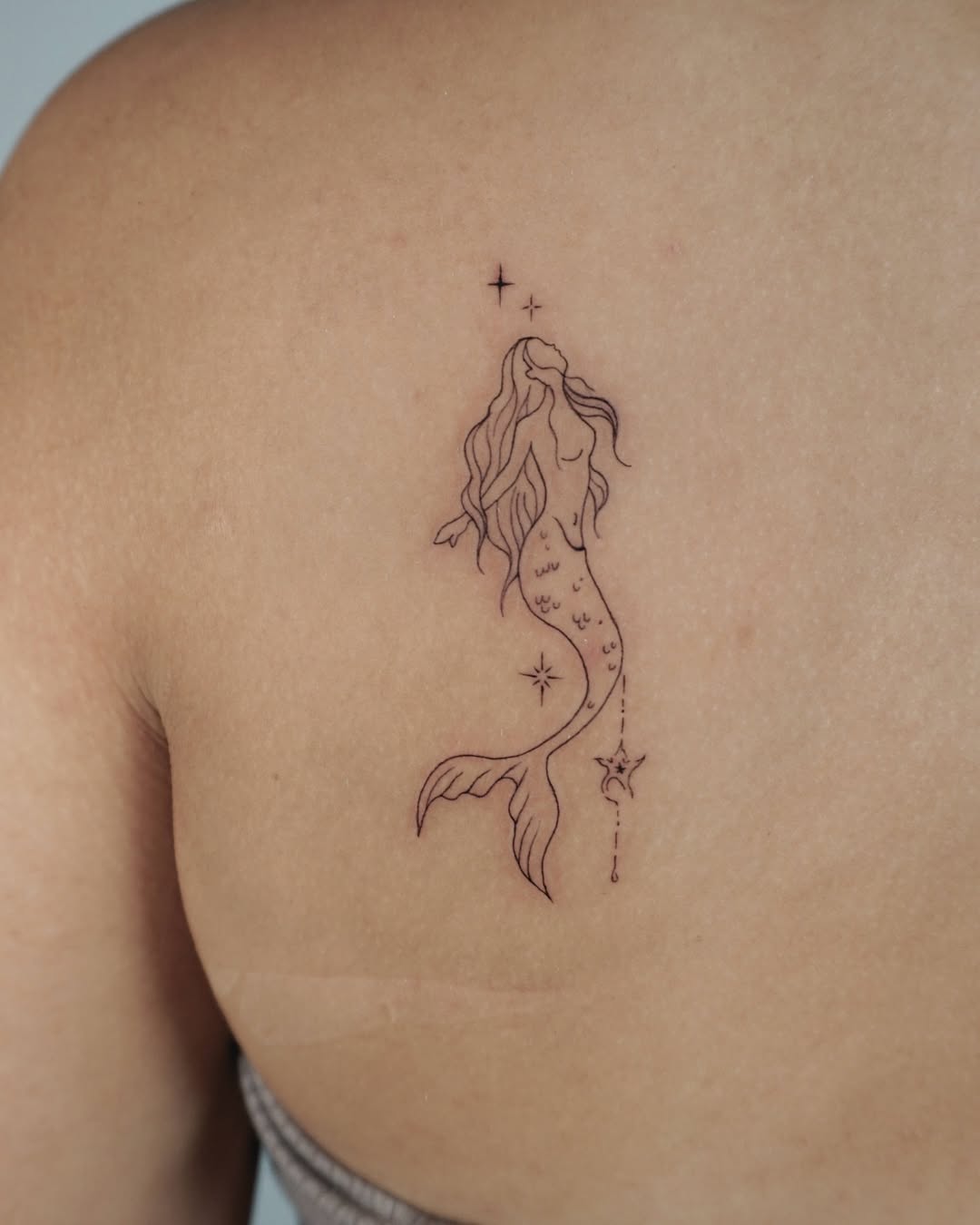 Elegant mermaid tattoo with celestial elements