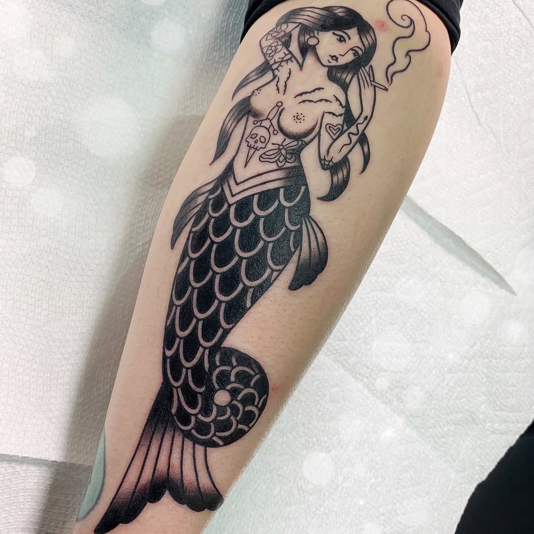 Bold black ink mermaid tattoo on arm