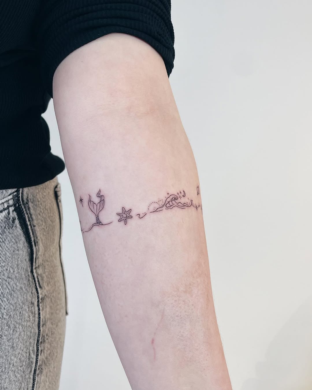 Delicate mermaid tattoo with ocean elements