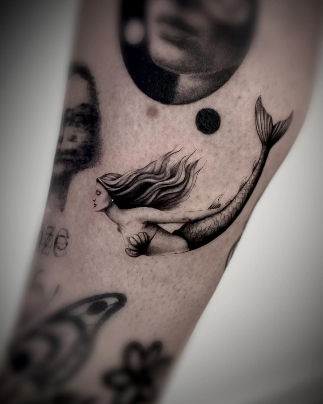 Elegant mermaid tattoo with flowing hair and tail