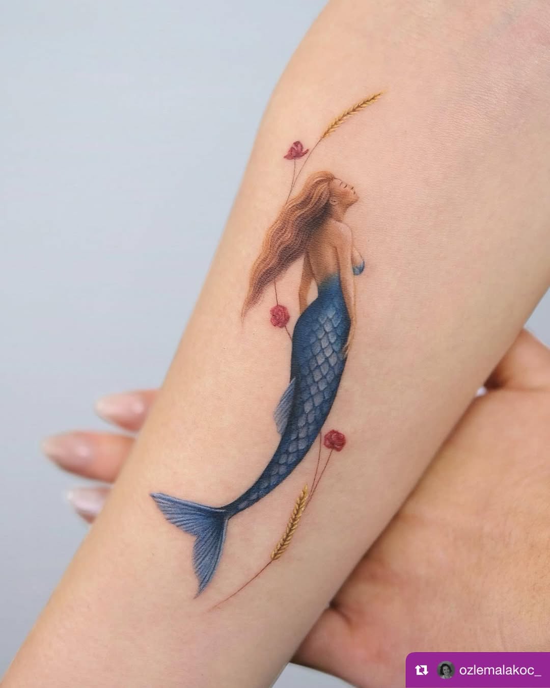 Elegant mermaid tattoo with floral accents
