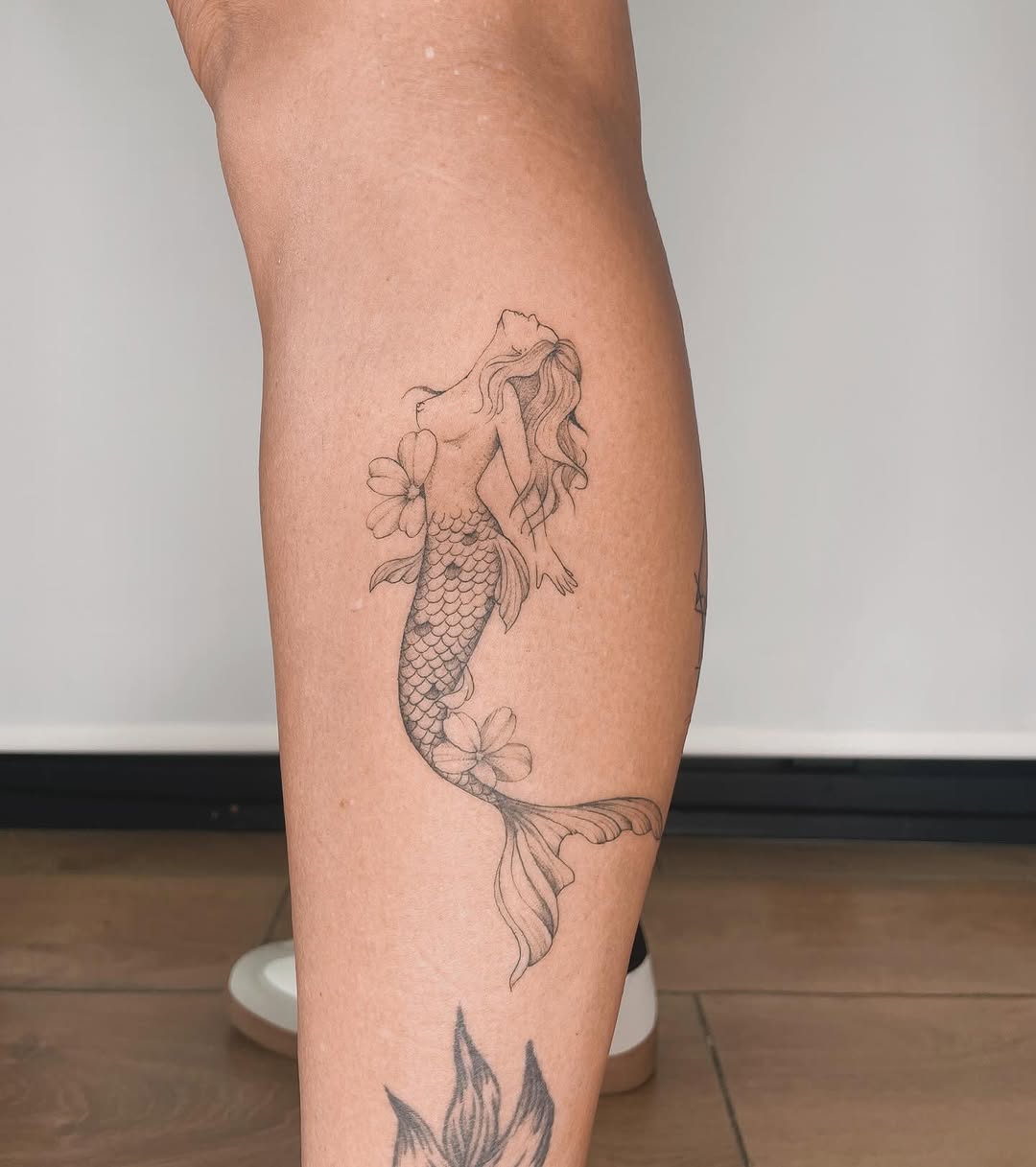 Elegant Mermaid Tattoo with Floral Accents